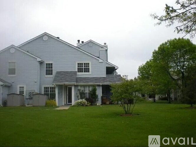 A house with a grey exterior and a tree in front.