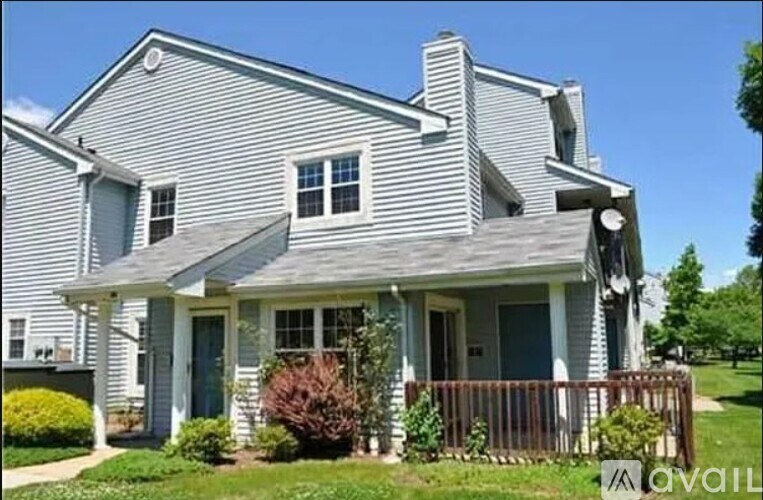 A house with a grey siding and a dark blue door.
