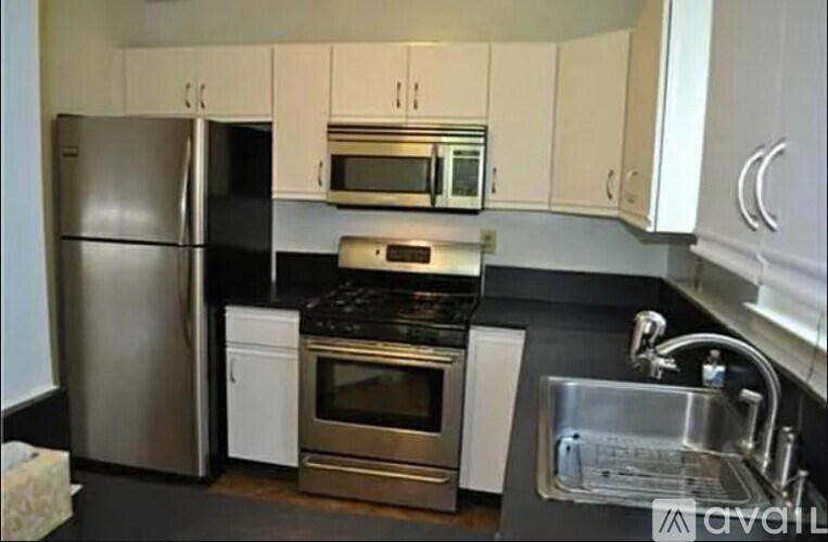 A kitchen with a stainless steel refrigerator, microwave, oven, and sink.