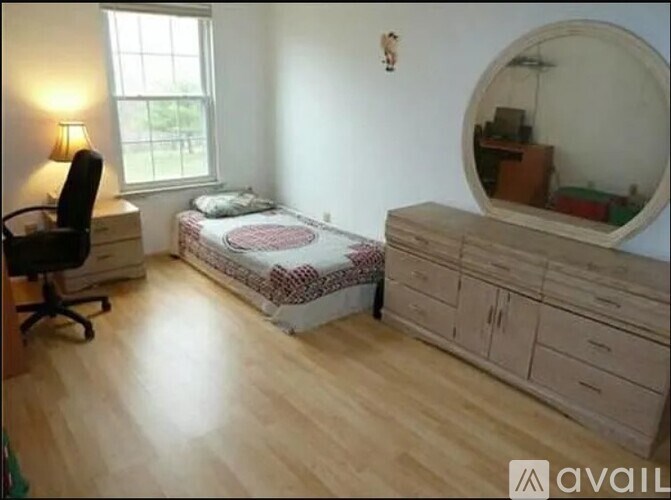 A bedroom with a round mirror on the wall.