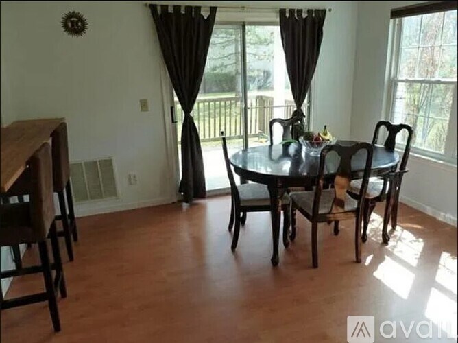 A dining room with a round table and chairs.
