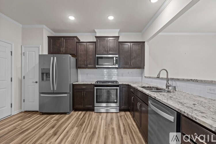 A kitchen with wooden floors and stainless steel appliances.