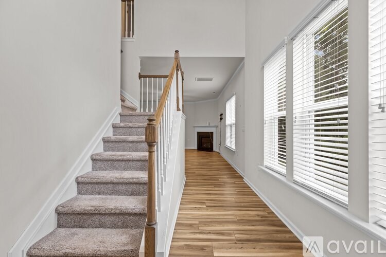 A staircase with a carpeted runner and wooden banister.