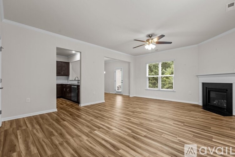 A spacious living room with wood flooring and a fireplace.