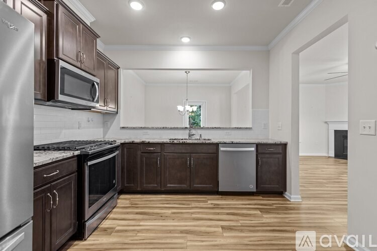 A kitchen with dark wood cabinets and stainless steel appliances.