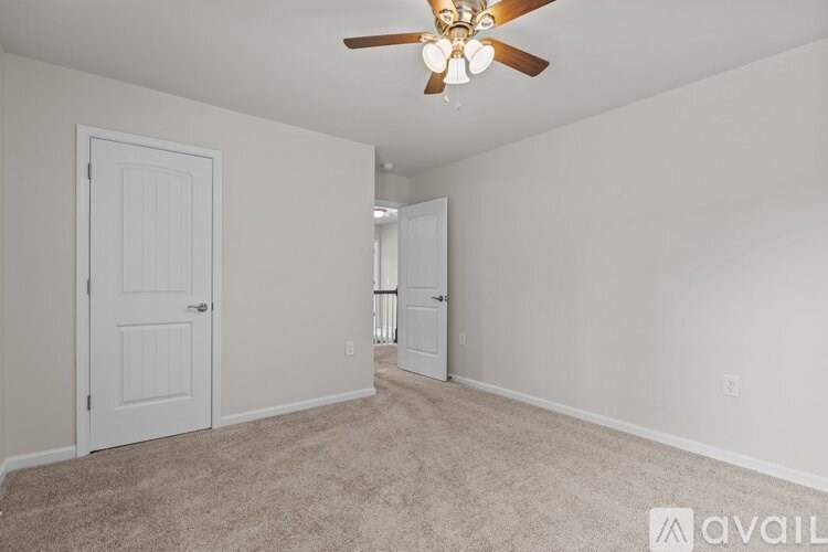 A room with a ceiling fan and two doors.