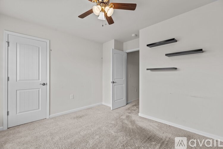 A room with a ceiling fan and two doors.