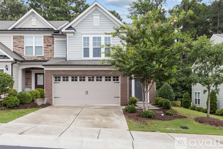 A two-story house with a garage and a driveway.