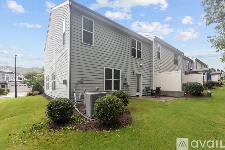 A grey house with a lawn in front.