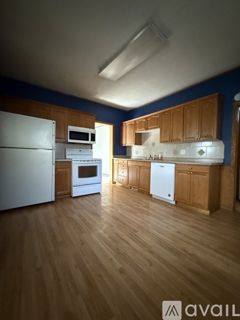A kitchen with wooden cabinets and a white refrigerator.