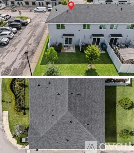 A bird's eye view of a white house with a red pin on the roof.