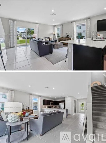 A modern living room with a kitchen area in the background.