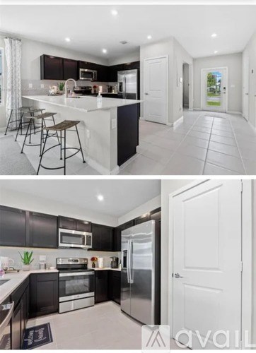 A modern kitchen with a refrigerator, oven, and microwave.