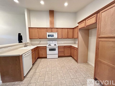 A kitchen with brown cabinets and a white stove top oven.