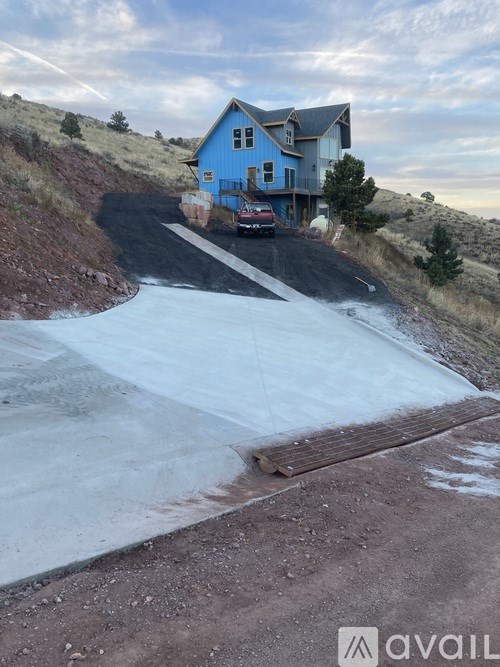 A blue house with a car parked in front of it.