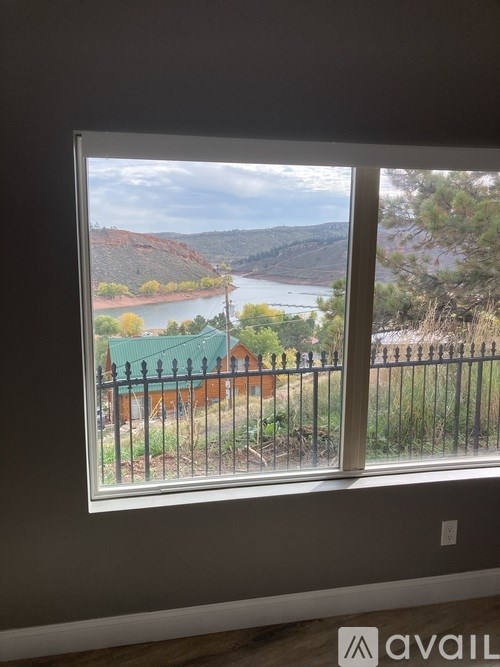 A window with a view of a river and a house.