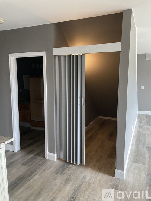 A room with a sliding door and a wooden floor.