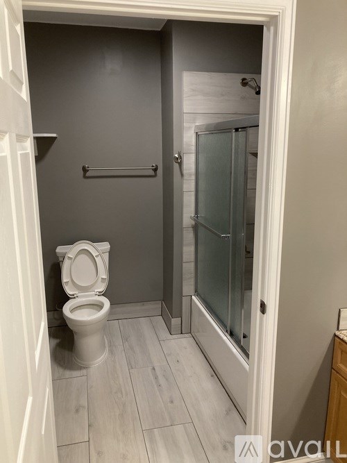 A white toilet in a small bathroom with a glass shower door.