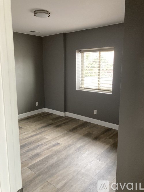 A room with a window and wooden flooring.
