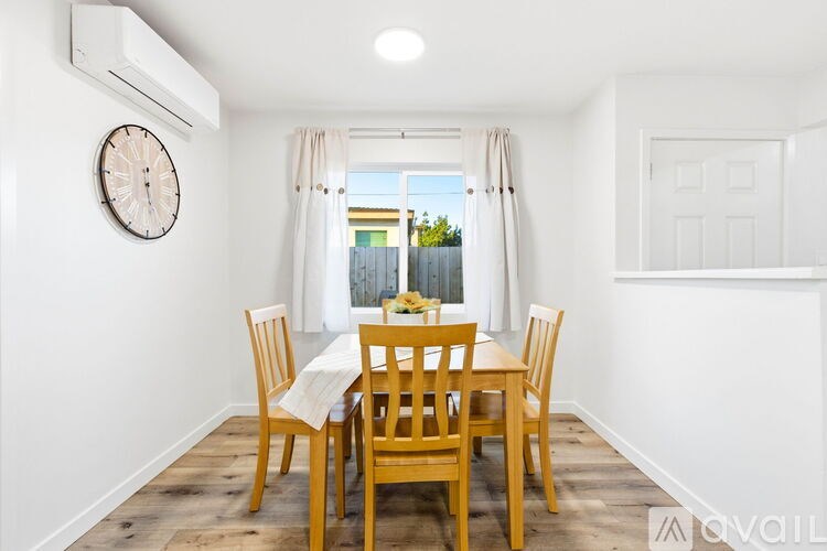 A dining room with a wooden table and chairs.