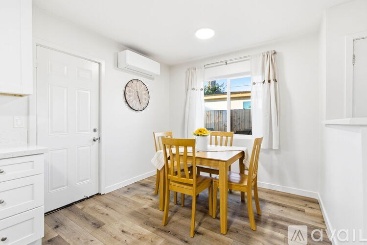 A dining room with a wooden table and chairs.