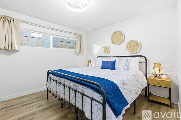 A bedroom with a bed, nightstand, and wall decor.