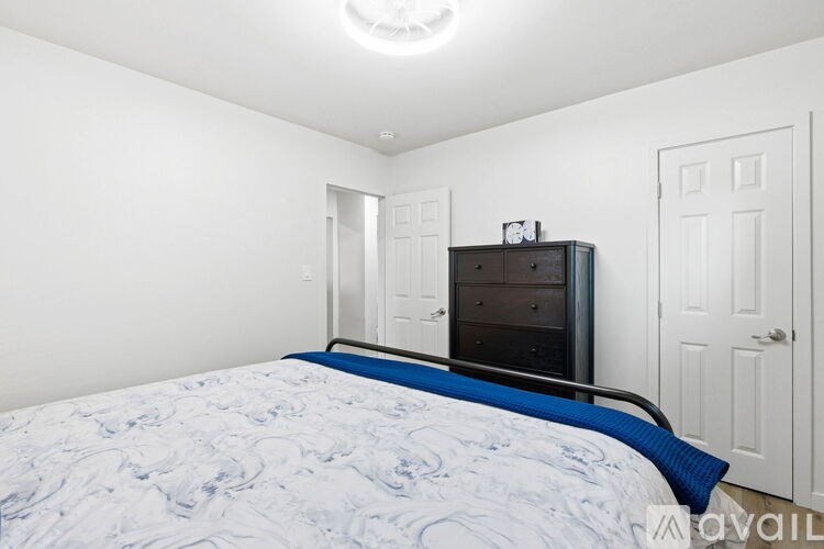 A bedroom with a bed, dresser, and mirror.