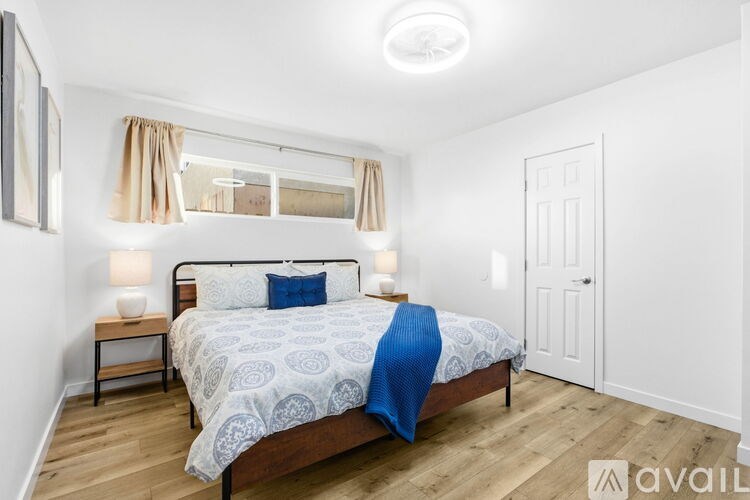 A bedroom with a bed, nightstands, and a window with curtains.