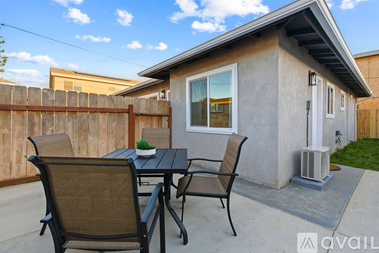 A patio with a table and chairs is set up outside a house.