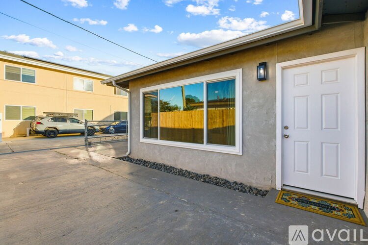 A house with a white door and a window showing a field.