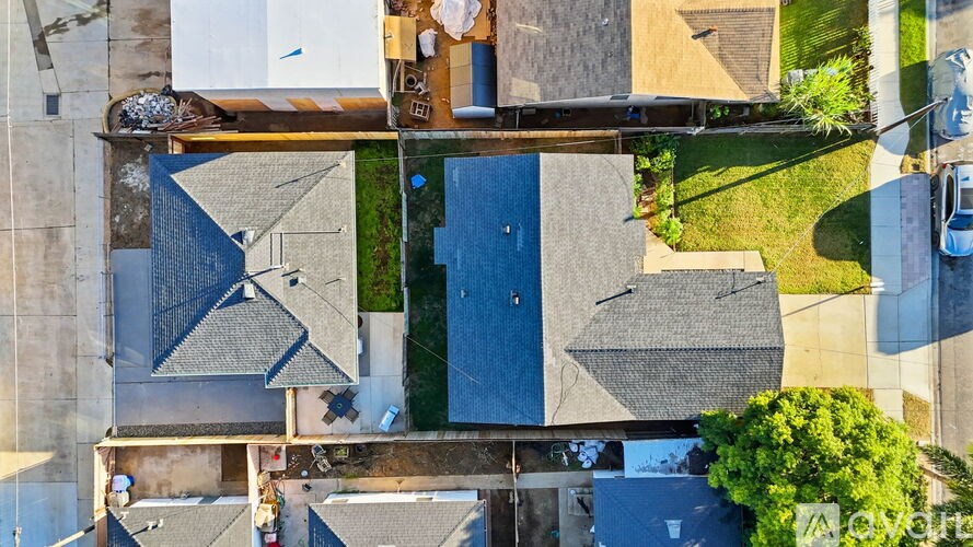 A bird's eye view of a residential area with houses and cars.