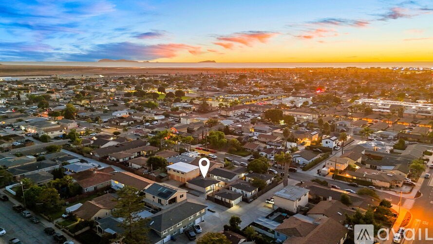 A sunset view of a residential neighborhood with a marker indicating a specific location.