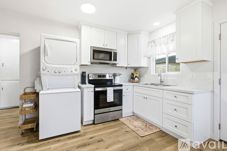 A kitchen with white appliances and cabinets.