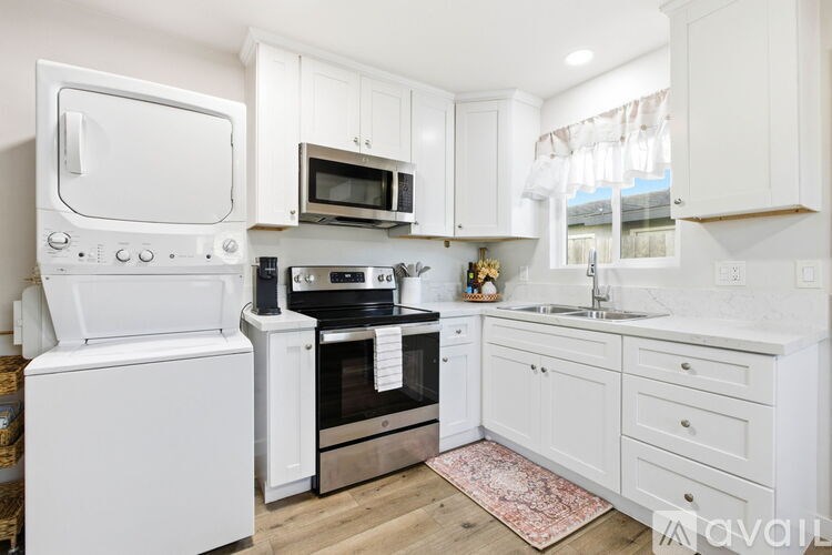 A kitchen with white appliances and cabinets.