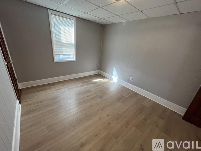 A room with wooden flooring and a window.