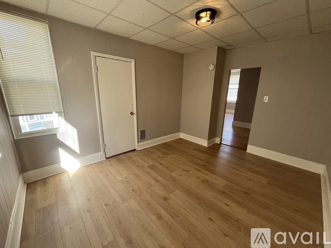 A room with wooden flooring and a white door.