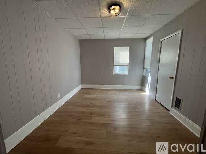 A room with wooden flooring and a window.