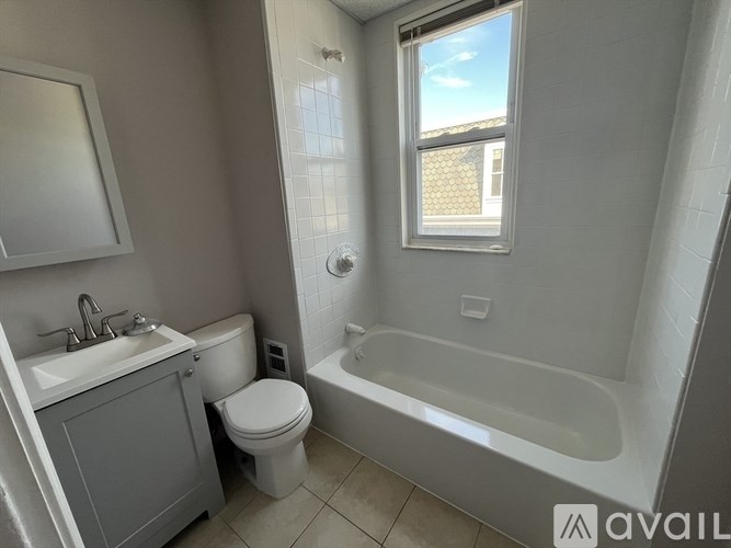 A bathroom with a toilet, sink, and bathtub.