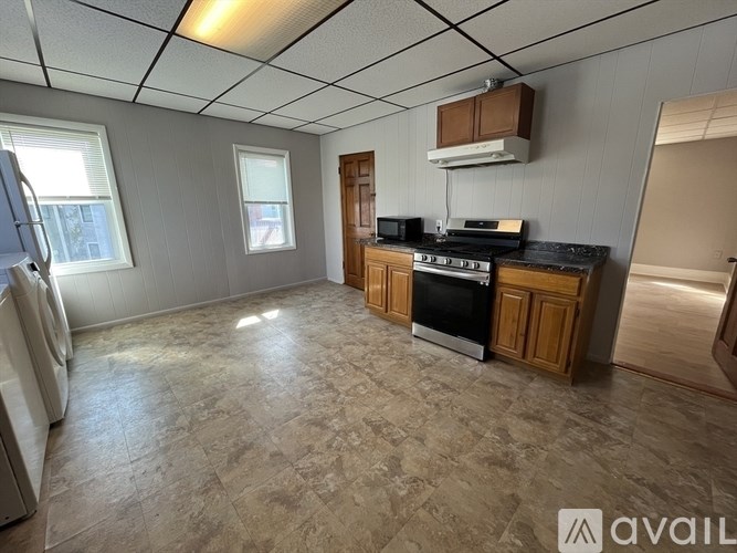 A kitchen with a washing machine in the corner.