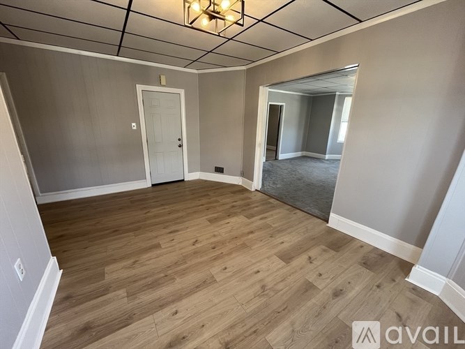 A room with wooden flooring and a white door.