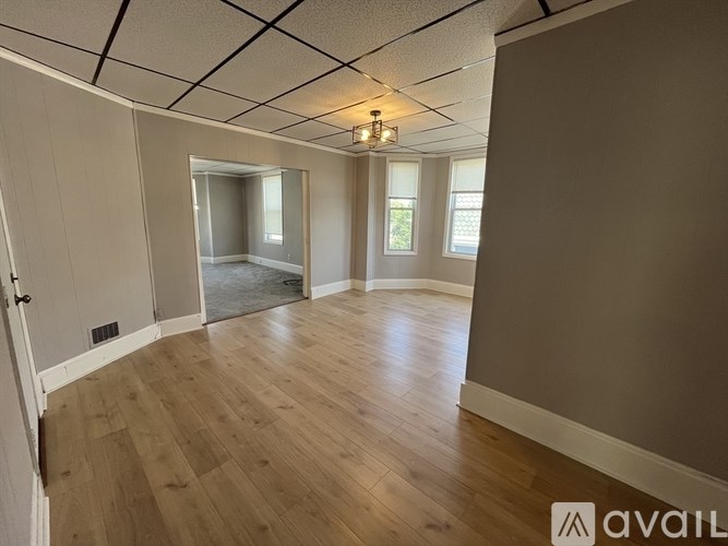 A room with wooden flooring and a ceiling with lights.