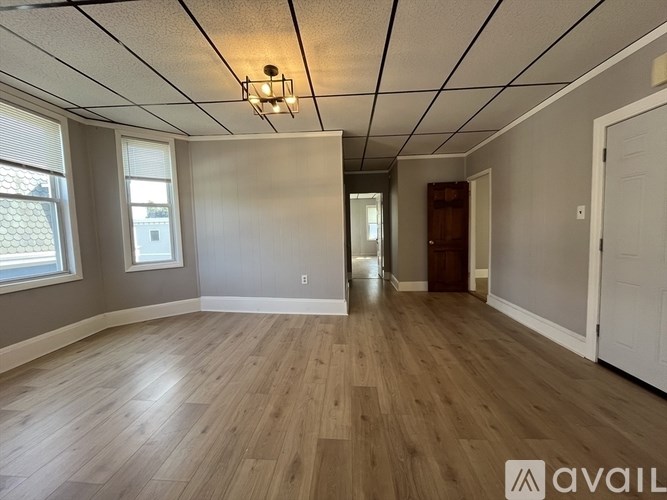 A room with wooden flooring and a white ceiling with a light fixture.