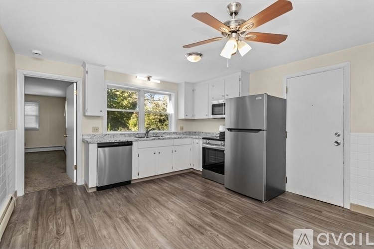A kitchen with a refrigerator, oven, and microwave.