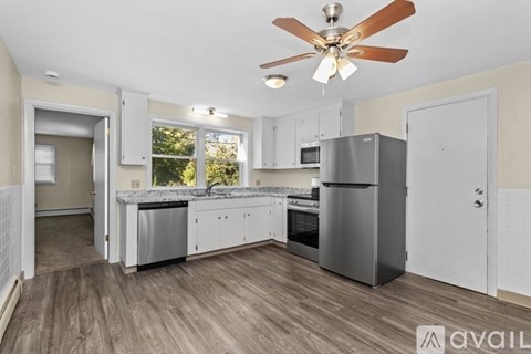 A kitchen with a refrigerator, oven, and microwave.