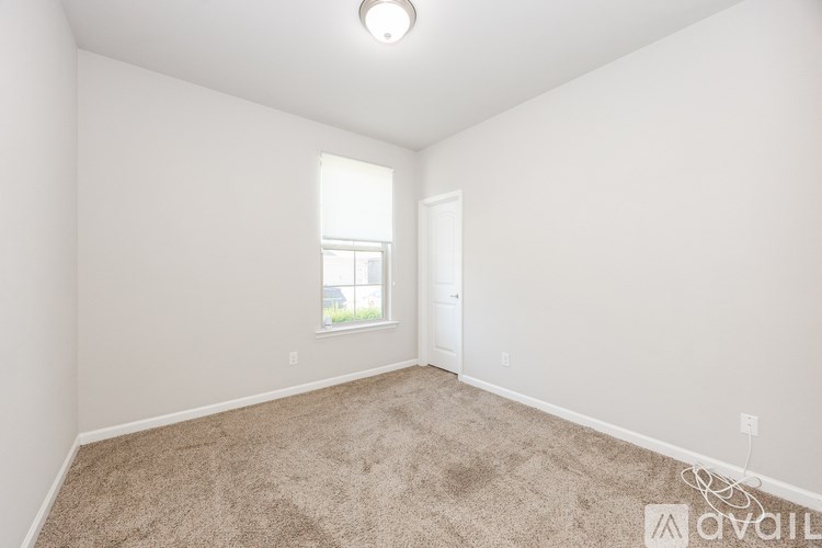 A room with a carpeted floor and a window.