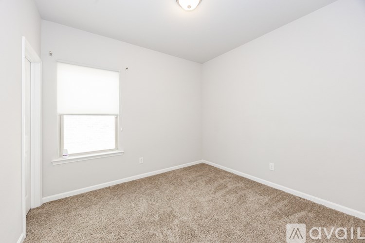 A room with a carpeted floor and a window.