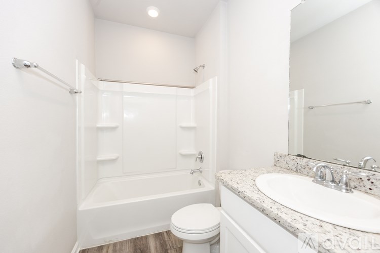 A white bathroom with a toilet, sink, and bathtub.