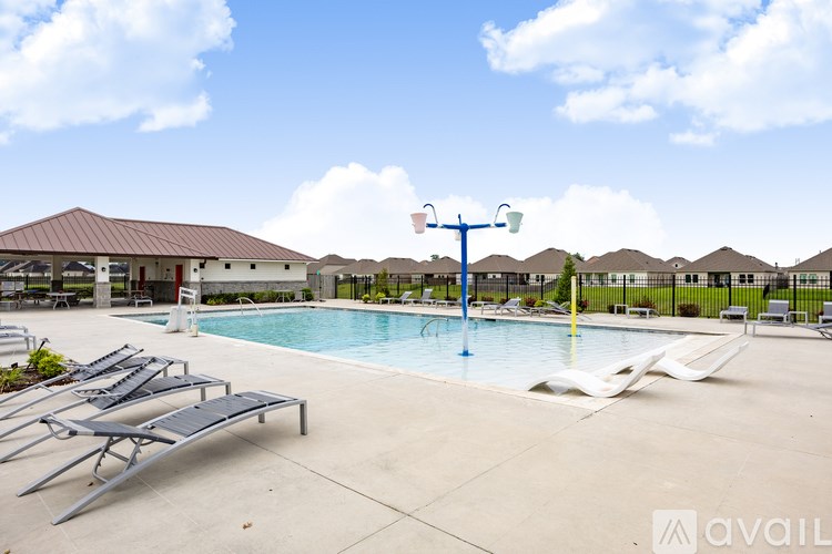 A pool with sun loungers and a diving board.