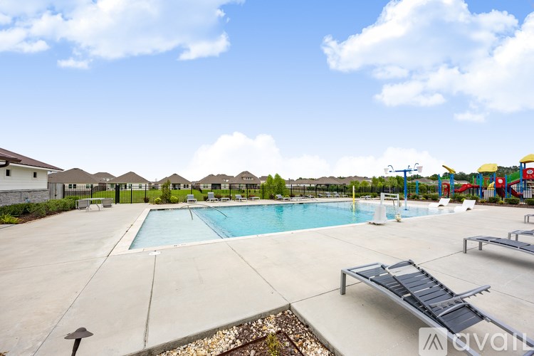 A large outdoor swimming pool with a slide and a ladder.