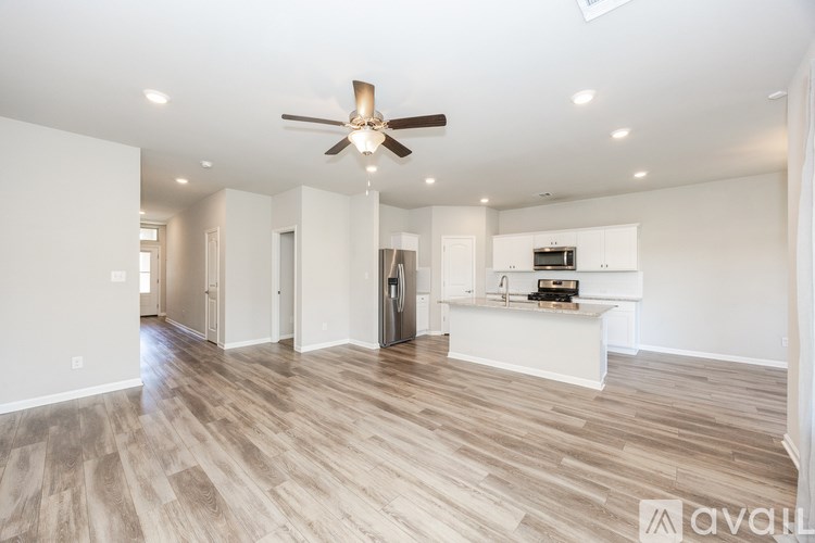 A spacious room with a ceiling fan and wooden flooring.